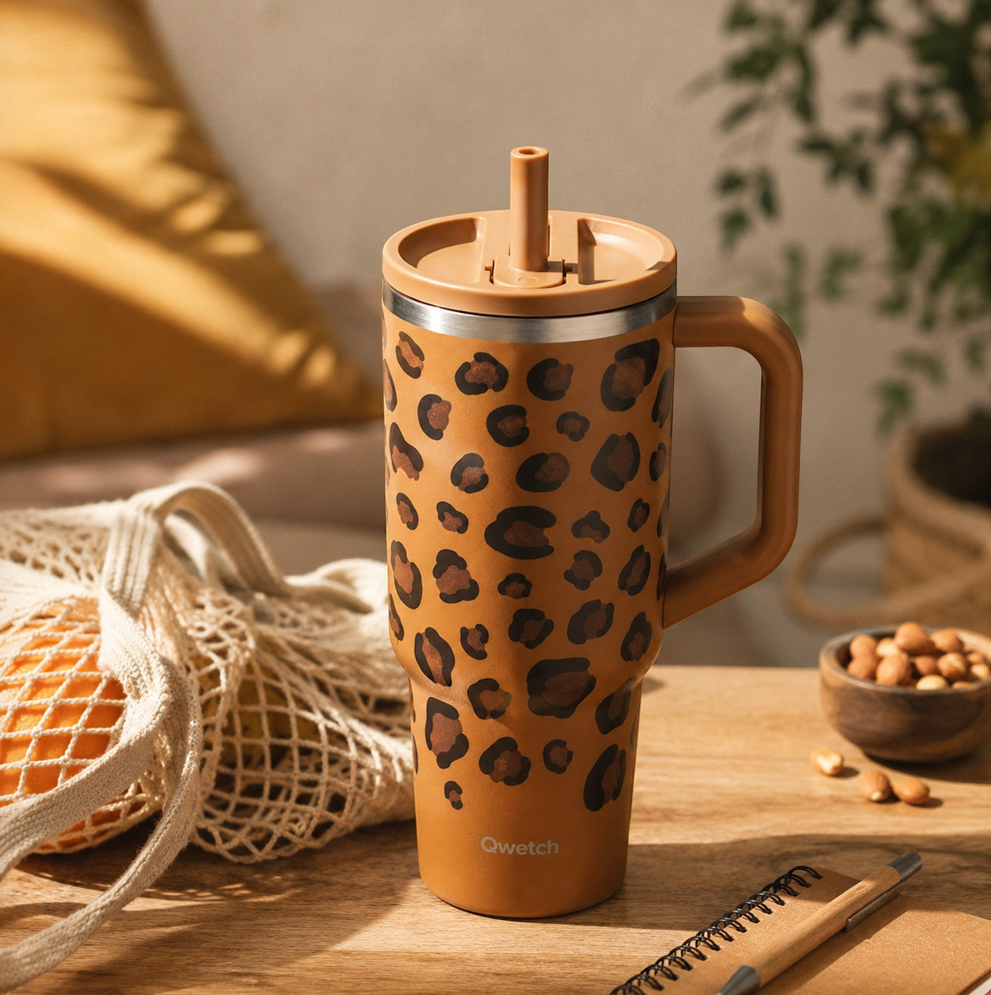 Gobelet isotherme Du Bruit dans la Cuisine Qwetch 900ml camel à motif léopard avec paille et poignée sur une table