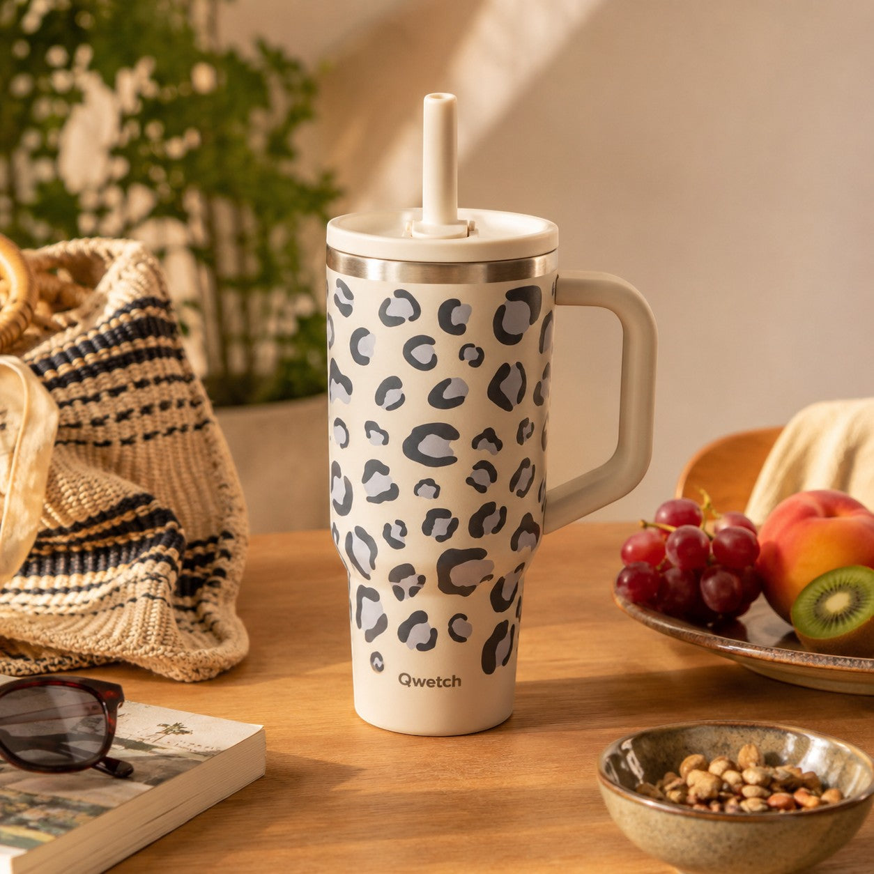 Gobelet isotherme 900ml Du Bruit dans la Cuisine motif léopard sable avec paille et anse sur une table en bois