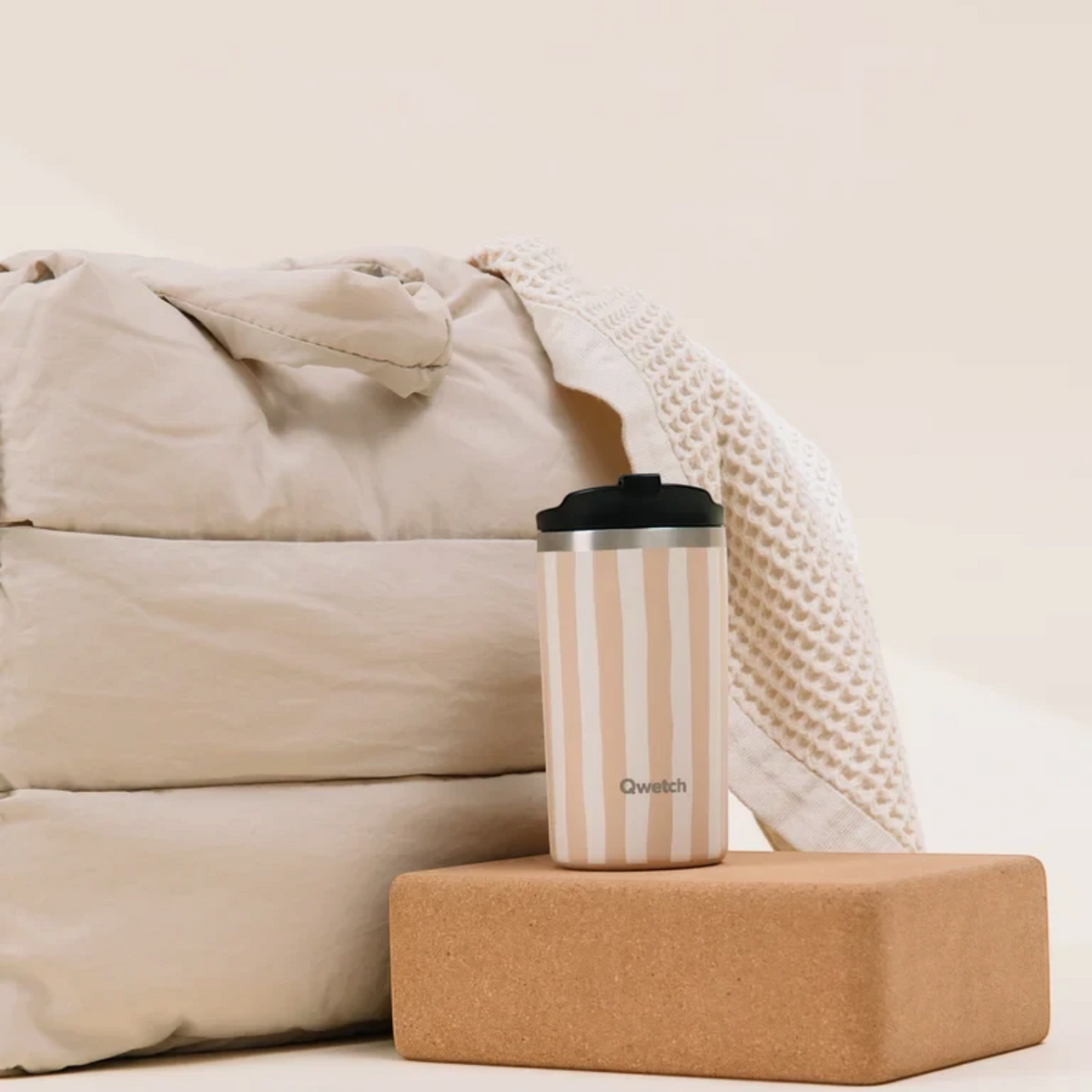 Mug isotherme Qwetch Allure Lin 350ml en inox beige rayé posé sur un bloc de liège chez Du Bruit dans la Cuisine