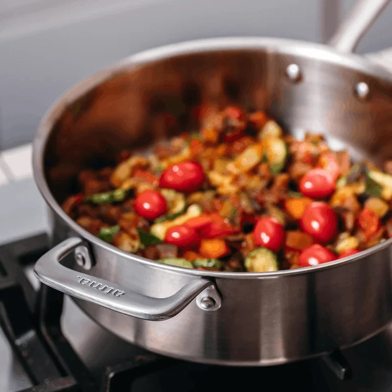 Sauteuse en inox 26cm Atma vendue par Du Bruit dans la Cuisine, contenant des légumes sautés avec des tomates cerises